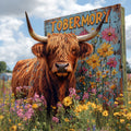 Tobermory the Highland cow in a field with a colourful 'Tobermory' sign in the background