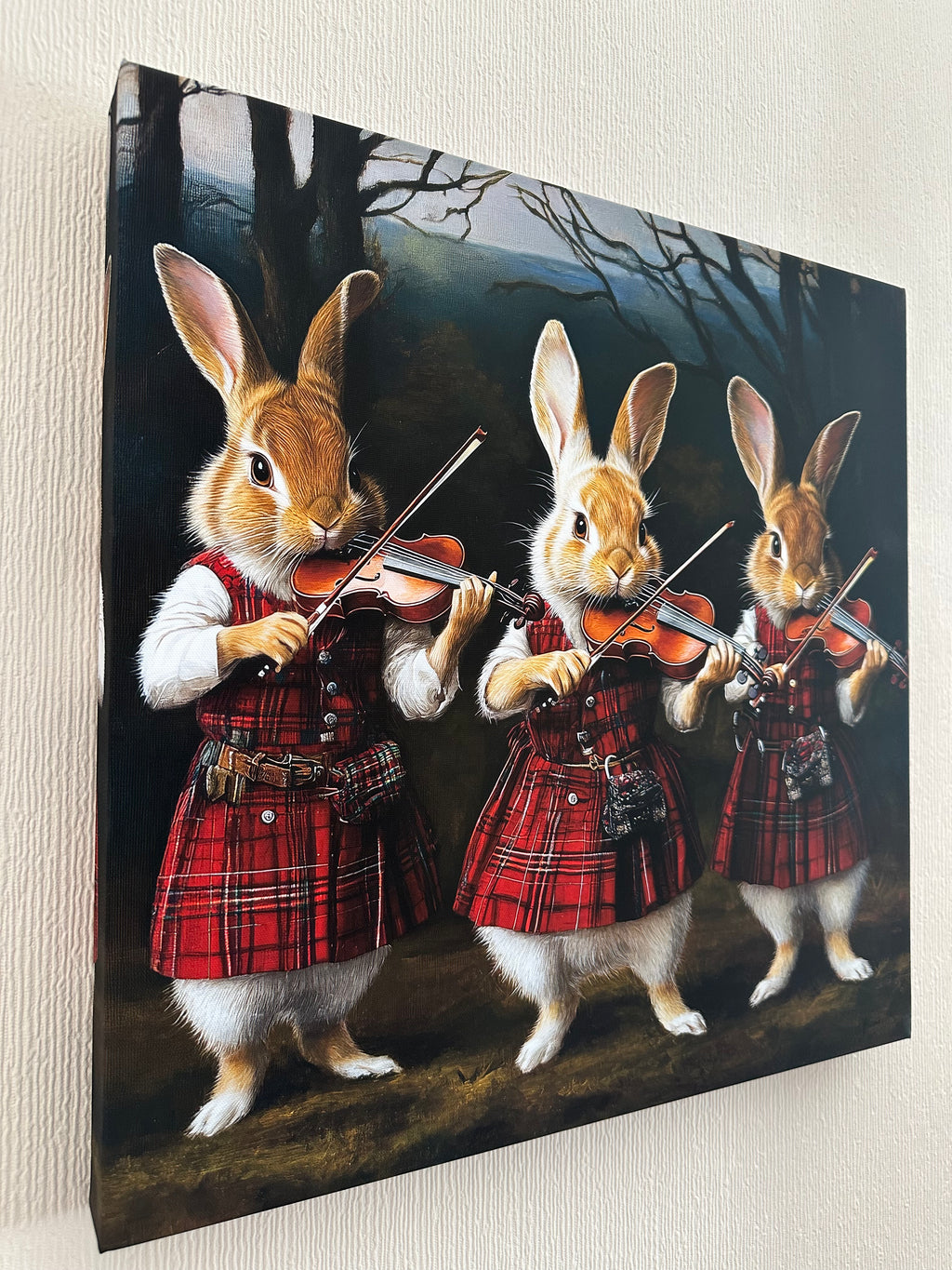 Framed artwork of rabbits playing violins with a person in a plaid skirt on a dark background.