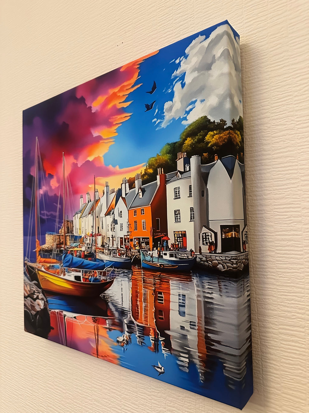 Framed artwork of a coastal scene with houses and boats on a colorful background.