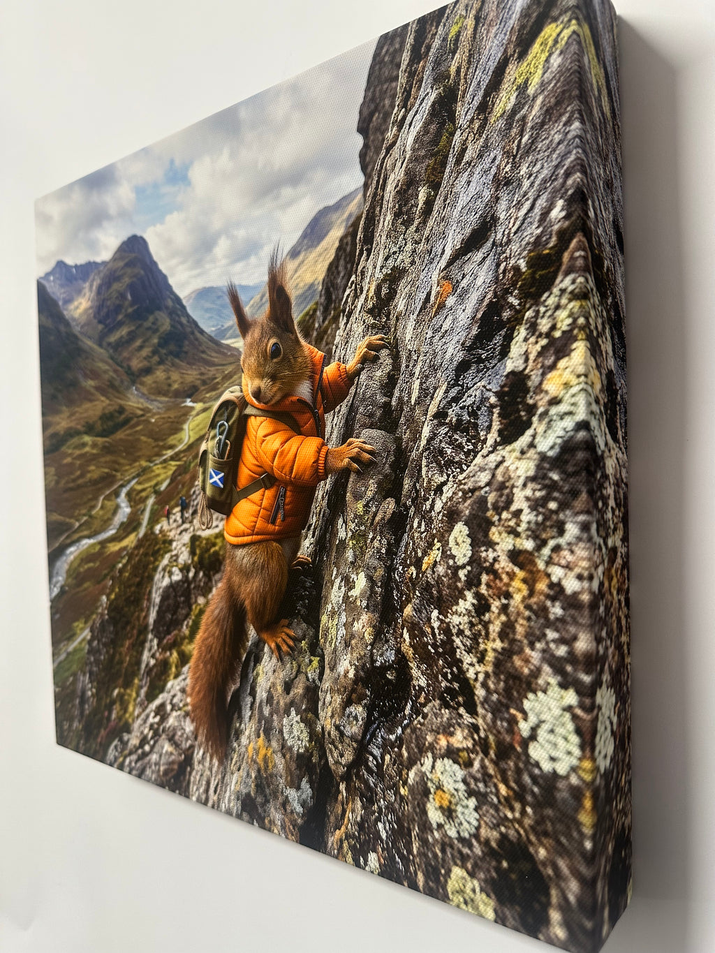 Squirrel in an orange jacket on a mountainous landscape